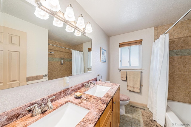 bathroom with a sink, visible vents, toilet, and double vanity