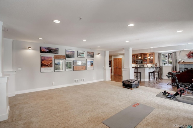 exercise room with ornate columns and light carpet