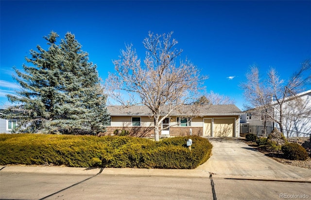 single story home featuring concrete driveway, brick siding, and an attached garage