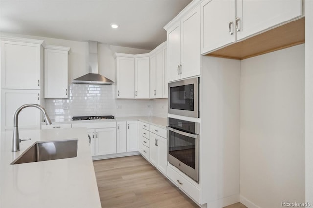 1257 Rhett Dr, Erie, CO 80026 - kitchen featuring oven, wall chimney range hood, a sink, built in microwave, and stovetop