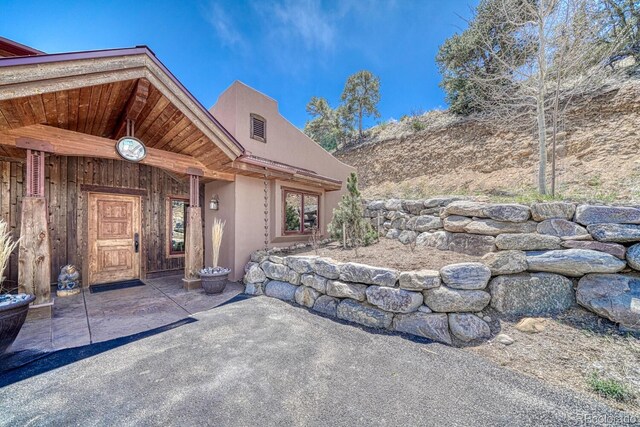 12220 Saddle Ridge Ln, Salida, CO 81201 - view of exterior entry with stucco siding and a patio area