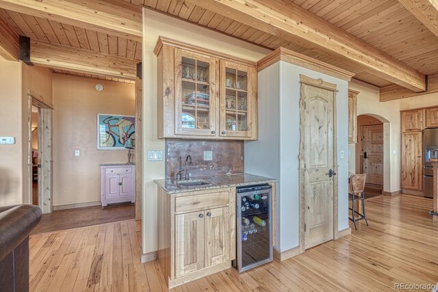 12220 Saddle Ridge Ln, Salida, CO 81201 - indoor wet bar featuring beverage cooler, beamed ceiling, wooden ceiling, arched walkways, and light wood-style flooring