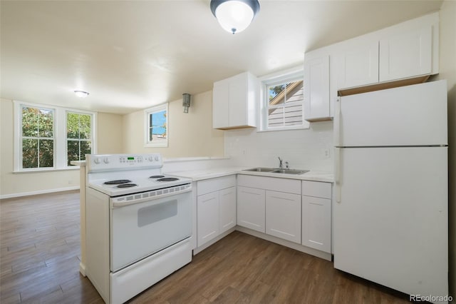 kitchen with kitchen peninsula, white appliances, dark wood-type flooring, sink, and white cabinetry