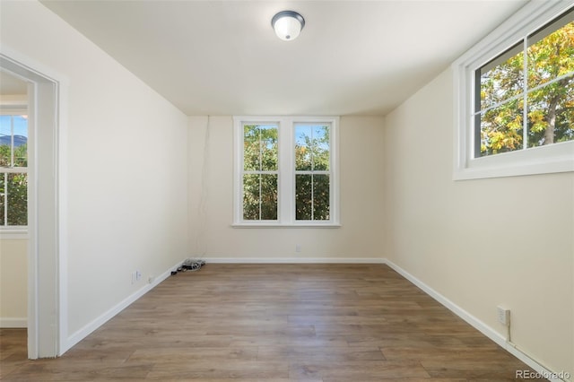 unfurnished room featuring a wealth of natural light and hardwood / wood-style floors