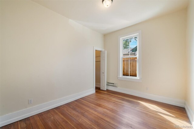 spare room with light wood-type flooring and baseboard heating