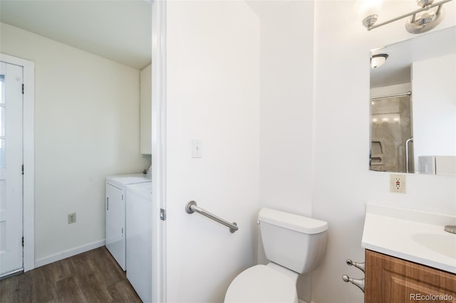 bathroom featuring separate washer and dryer, hardwood / wood-style flooring, vanity, and toilet