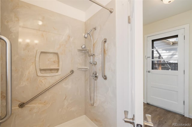 bathroom with hardwood / wood-style flooring and walk in shower