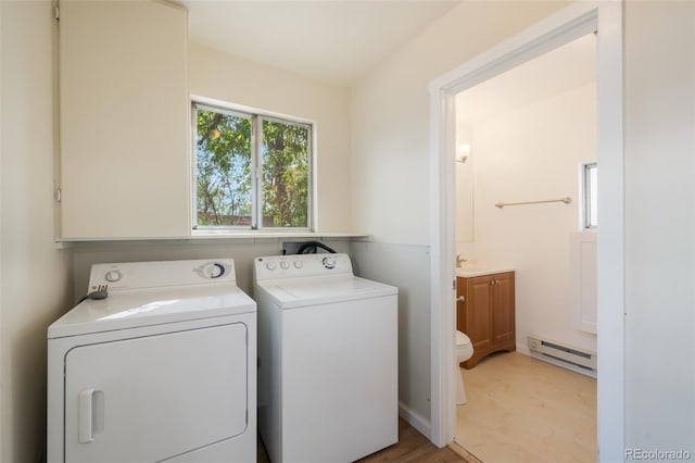 laundry area featuring light tile patterned flooring, separate washer and dryer, sink, and a baseboard heating unit