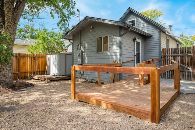 rear view of property with a shed and a deck