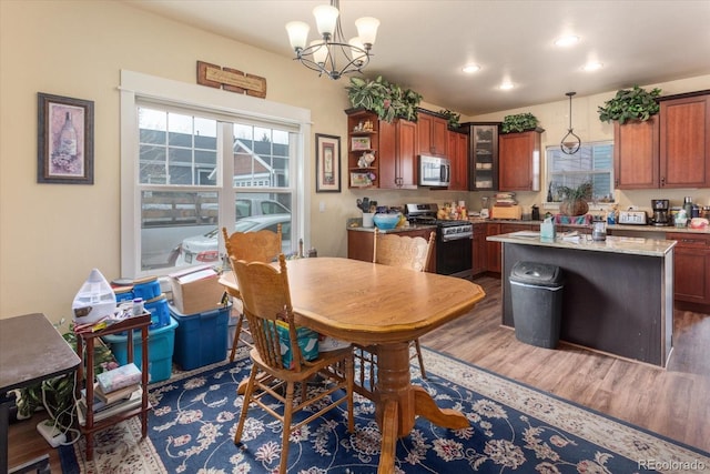 dining area featuring dark wood-style flooring, recessed lighting, and an inviting chandelier