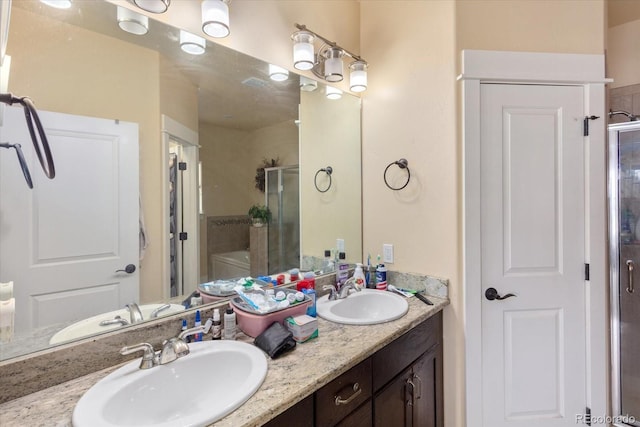 full bath featuring double vanity, a sink, and a shower stall