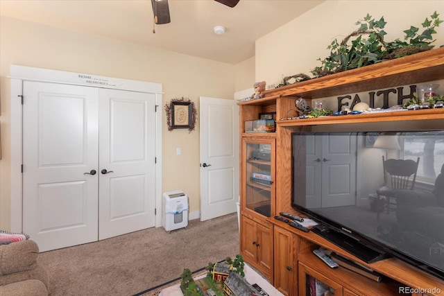 interior space featuring ceiling fan and light colored carpet