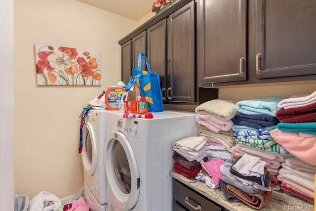 washroom featuring washing machine and dryer and cabinet space