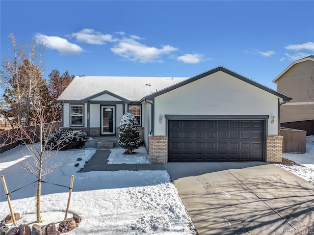 ranch-style home with fence, an attached garage, brick siding, stucco siding, and driveway