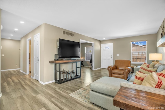 living room with recessed lighting, baseboards, visible vents, and wood finished floors