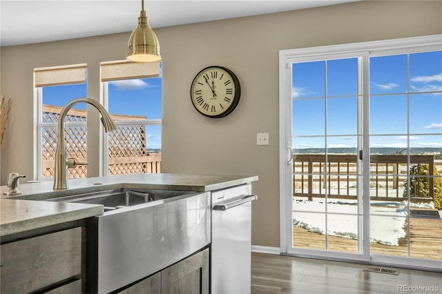 kitchen with a sink, hanging light fixtures, visible vents, and a healthy amount of sunlight