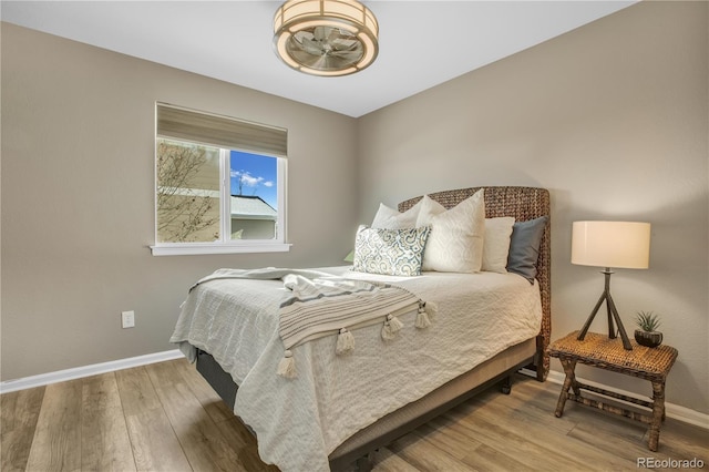 bedroom featuring baseboards and wood finished floors