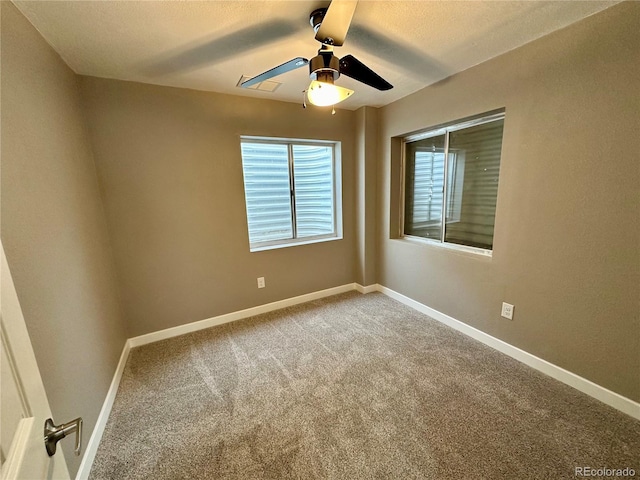 empty room with baseboards, ceiling fan, carpet, and a textured ceiling