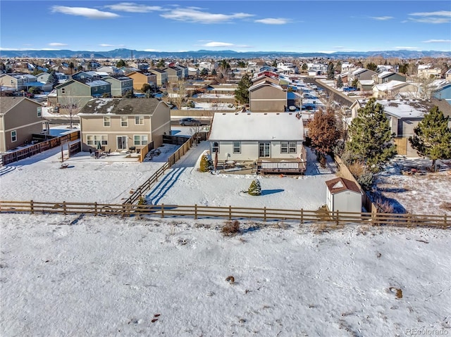 snowy aerial view featuring a residential view and a mountain view