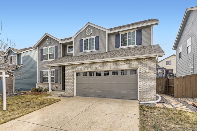 traditional-style home featuring fence, driveway, a shingled roof, a garage, and brick siding