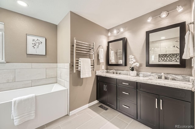 full bath featuring double vanity, a garden tub, a tile shower, and a sink