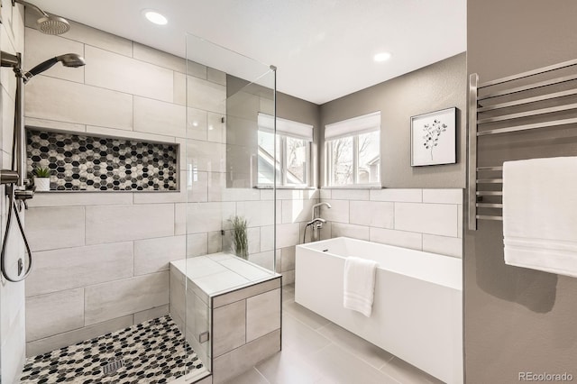 bathroom featuring tile patterned floors, a freestanding tub, radiator, tile walls, and tiled shower