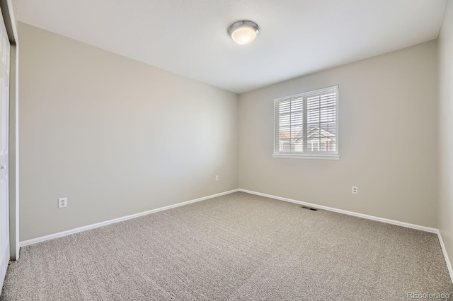 carpeted empty room with visible vents and baseboards