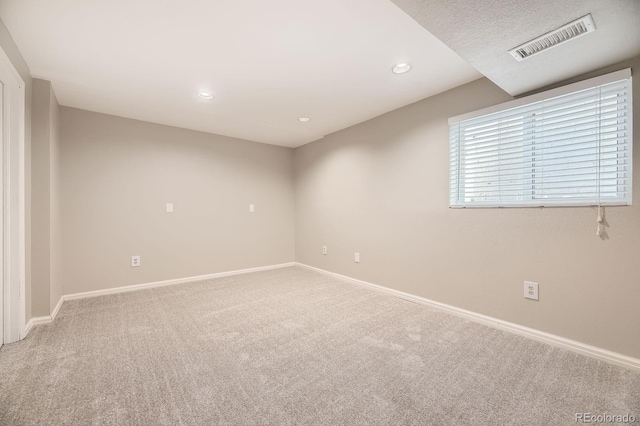 carpeted spare room featuring recessed lighting, visible vents, and baseboards