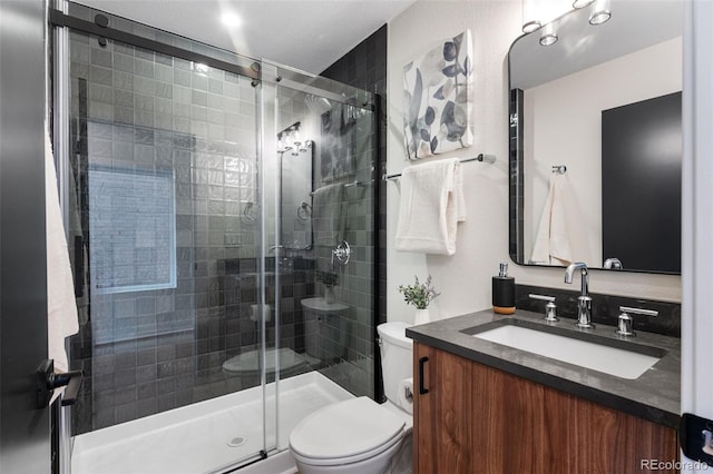 full bath featuring vanity, a shower stall, and toilet