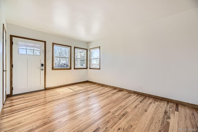 entrance foyer with baseboards, a wealth of natural light, and light wood-style floors