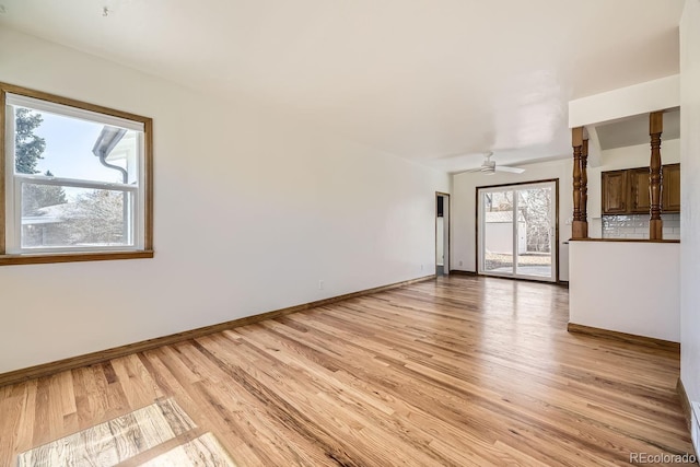 unfurnished living room featuring light wood-style floors, baseboards, and a ceiling fan