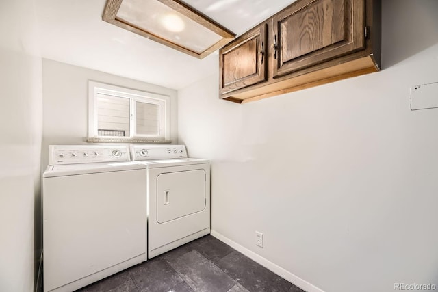 clothes washing area featuring cabinet space, baseboards, and separate washer and dryer