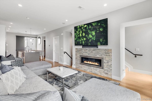 3103 W 18th Ave, Denver, CO 80204 - living room featuring a stone fireplace, wood finished floors, recessed lighting, and stairway