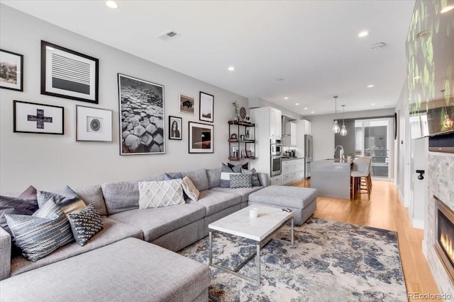 3103 W 18th Ave, Denver, CO 80204 - living area featuring light wood-style floors, recessed lighting, and a glass covered fireplace