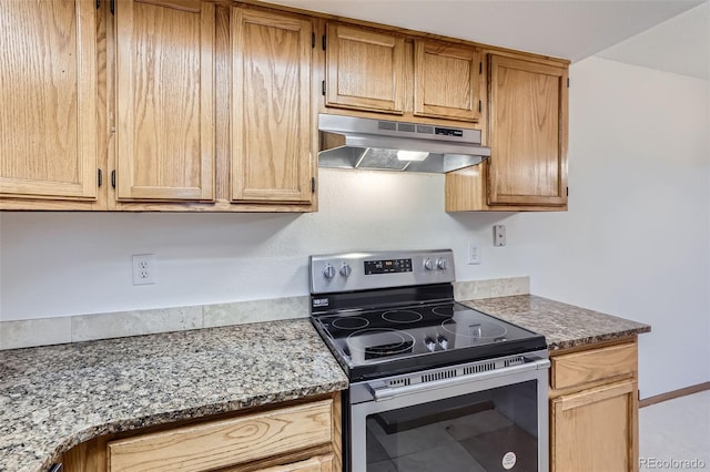 kitchen with dark stone counters, electric stove, and tile patterned flooring