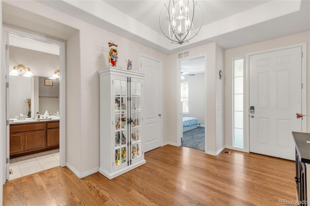 9904 Quintero St, Commerce City, CO 80022 - foyer entrance with light wood-type flooring and a chandelier