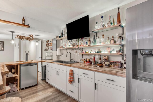9904 Quintero St, Commerce City, CO 80022 - indoor wet bar featuring appliances with stainless steel finishes, light wood-style flooring, and decorative light fixtures
