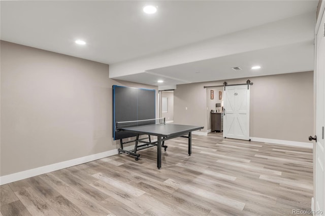 9904 Quintero St, Commerce City, CO 80022 - recreation room featuring a barn door, light wood-style floors, and recessed lighting