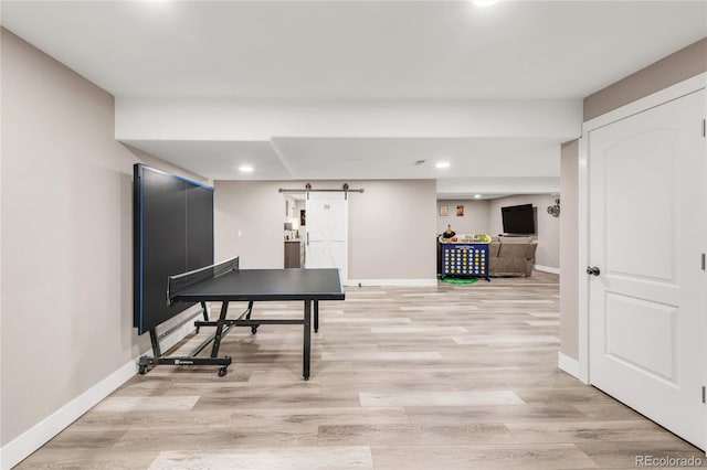 9904 Quintero St, Commerce City, CO 80022 - recreation room featuring a barn door, light wood-style flooring, and recessed lighting