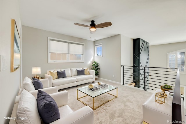 living room with baseboards, ceiling fan, and carpet flooring