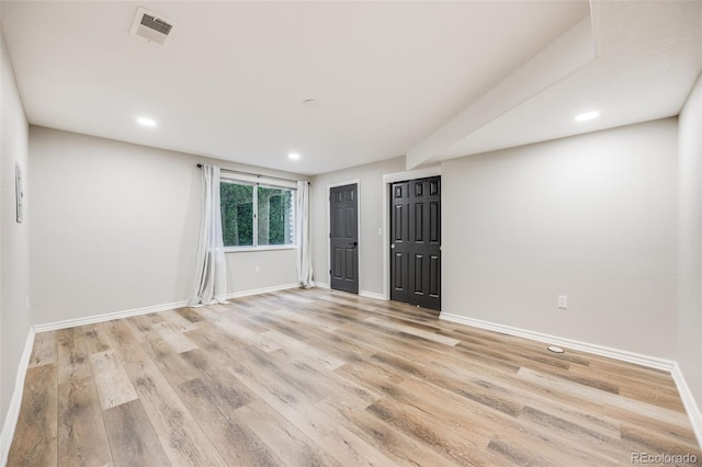 spare room featuring light wood-style flooring, recessed lighting, baseboards, and visible vents