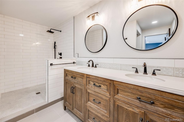 full bath with a sink, tasteful backsplash, double vanity, and a tile shower