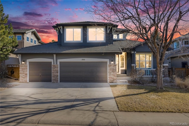 view of front of home featuring concrete driveway, a tiled roof, and a garage