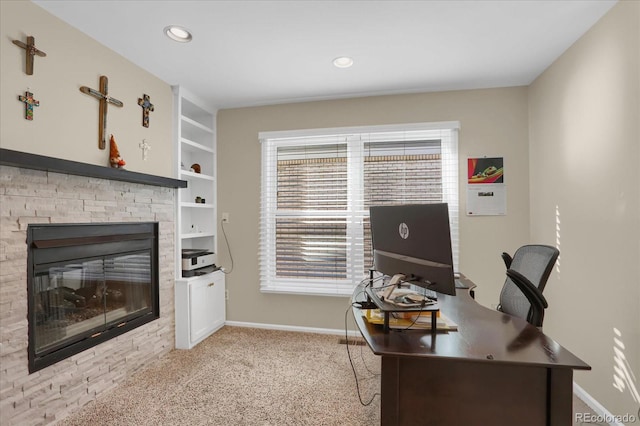 carpeted office space featuring a fireplace and built in features