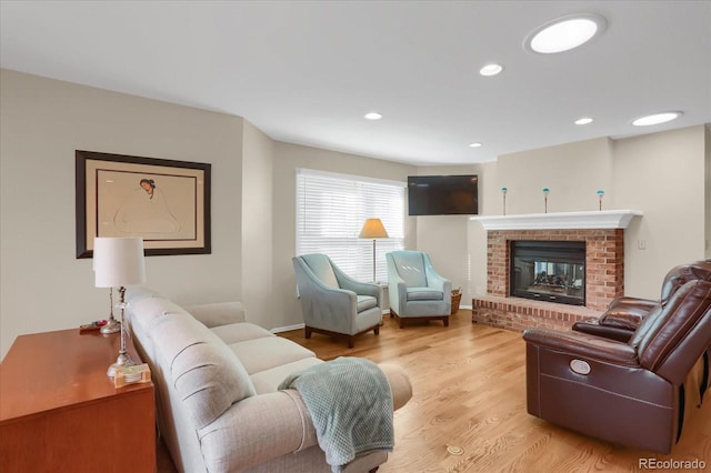 living room featuring light hardwood / wood-style floors and a brick fireplace