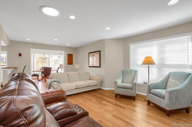 living room featuring light wood-type flooring and a chandelier