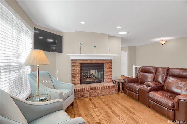 living room with light wood-type flooring and a fireplace