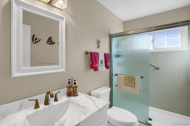 bathroom with a shower with door, vanity, and toilet