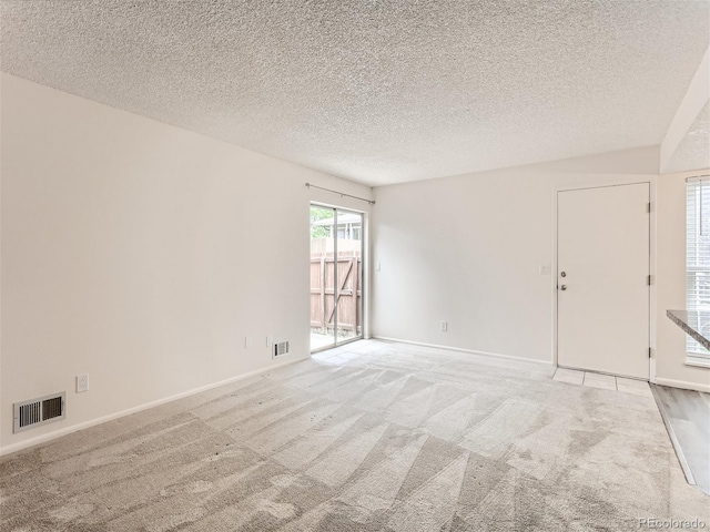 carpeted spare room featuring a textured ceiling