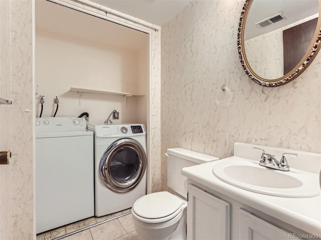 washroom featuring light tile patterned flooring, sink, and independent washer and dryer